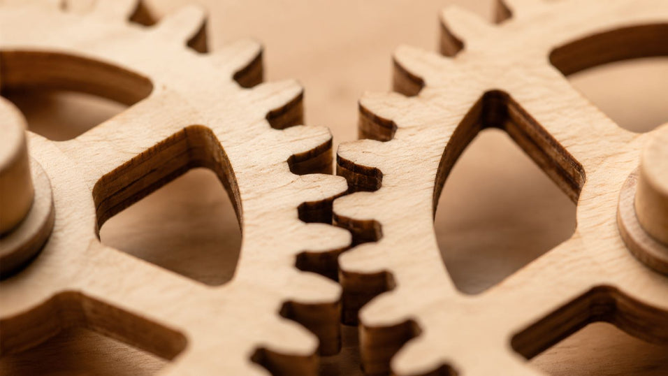 Close-up of interlocking wooden gears in a mechanical 3D puzzle, demonstrating kinetic movement and precise engineering.