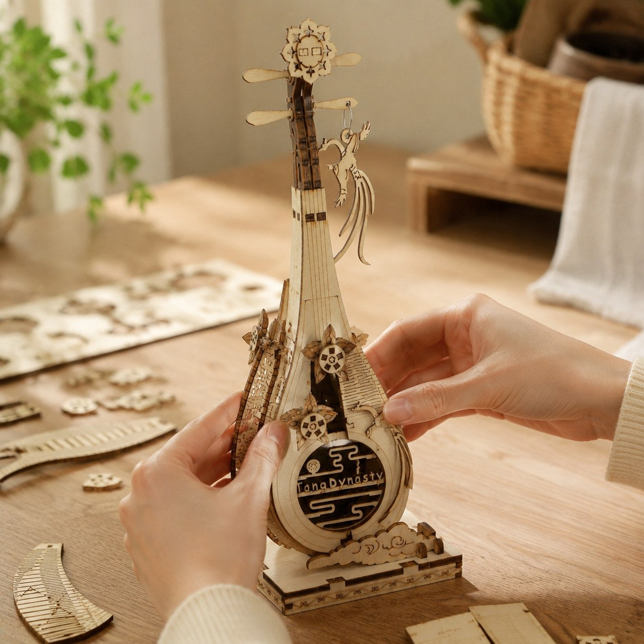 Adult hands assembling the curved back of the wooden Pipa puzzle