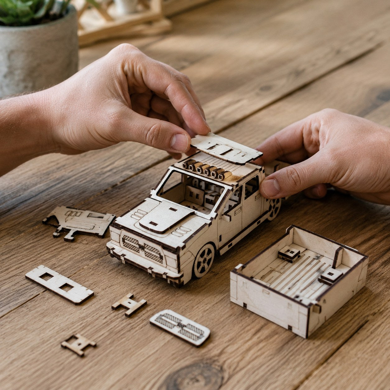 Adult hands assembling a wooden pickup truck 3D puzzle on a workbench