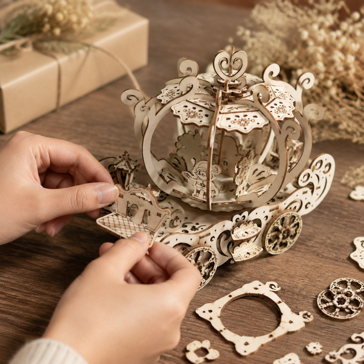 Person assembling the wooden pumpkin carriage puzzle
