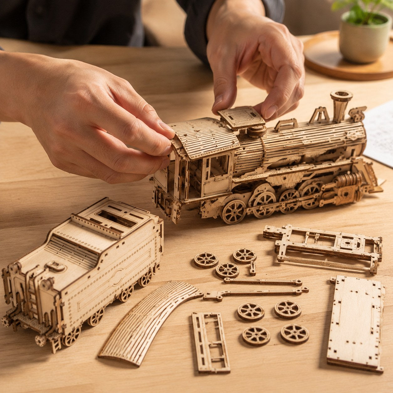 Adult hands assembling a wooden steam train model kit on a workbench.
