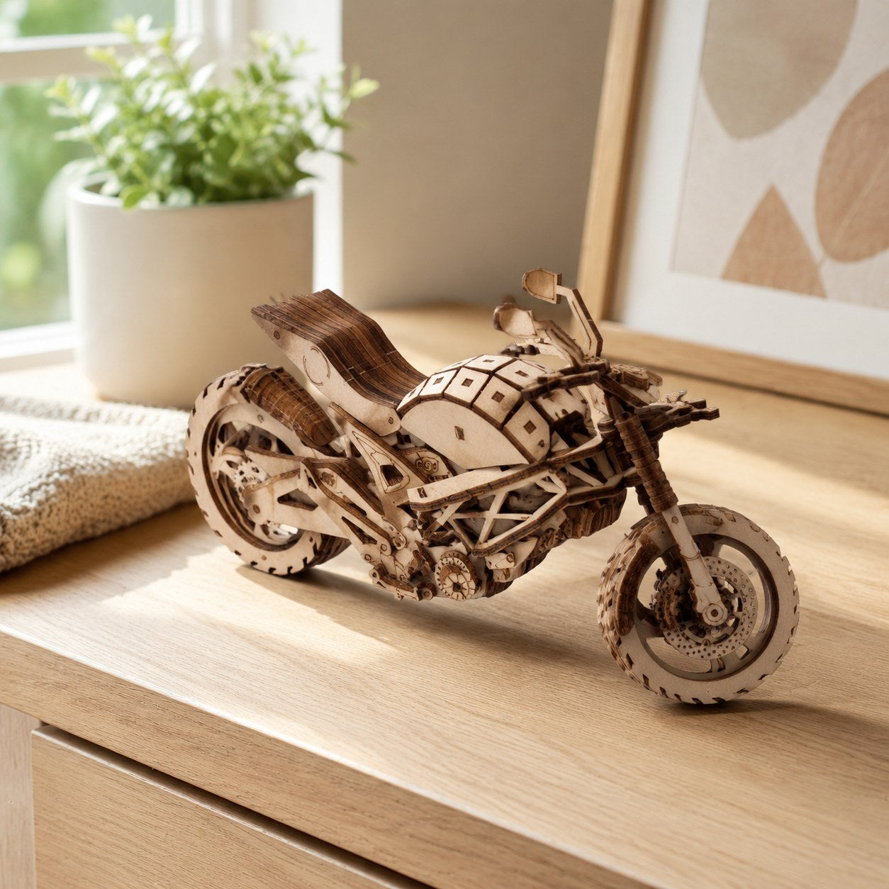 Cruiser motorcycle wooden model displayed on a desk in a cozy room.
