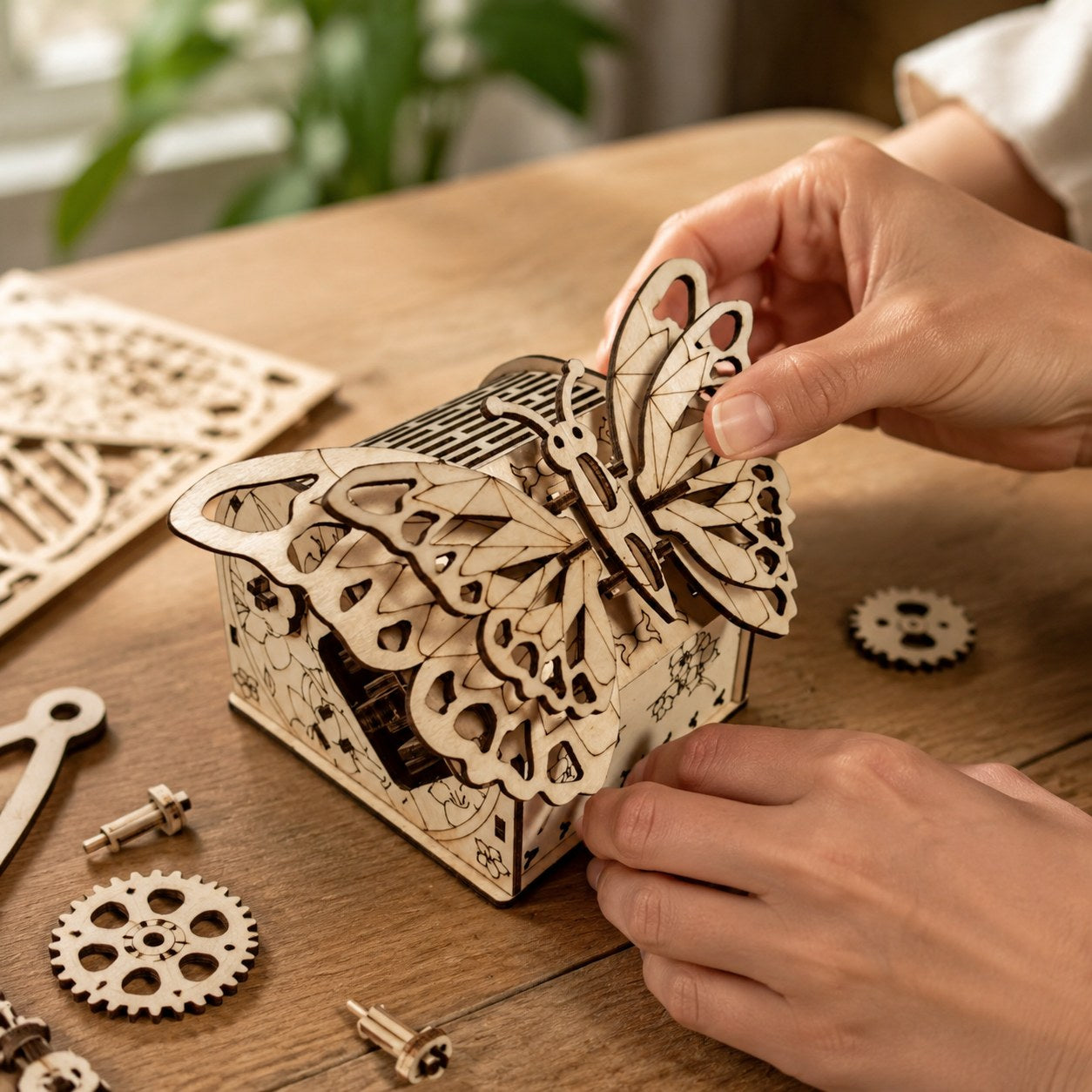 Hands building a mechanical wooden butterfly model.