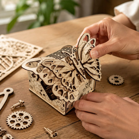 Hands building a mechanical wooden butterfly model.