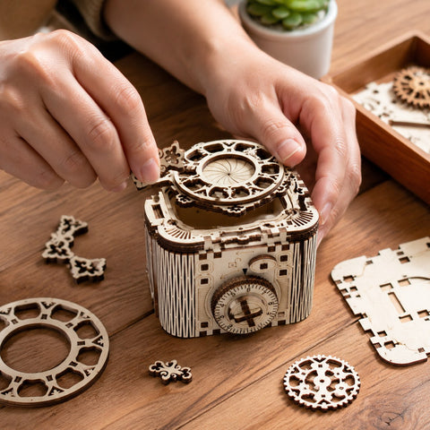 Adult hands assembling the wooden mechanical cipher box on a workbench