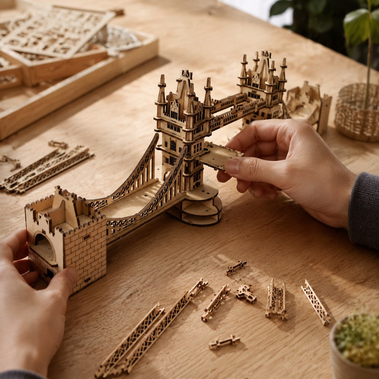 Adult hands assembling the London Tower Bridge 3D wooden puzzle on a workbench