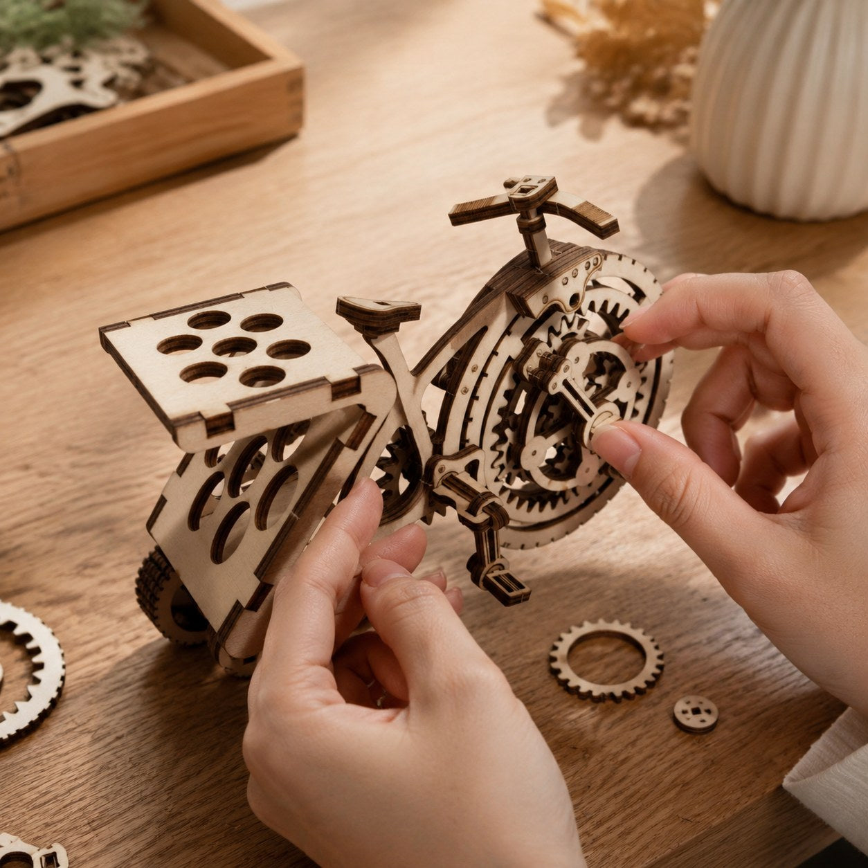 Adult hands assembling the wooden tricycle gear wheel
