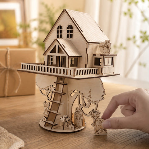 Hand next to the finished wooden treehouse model for scale