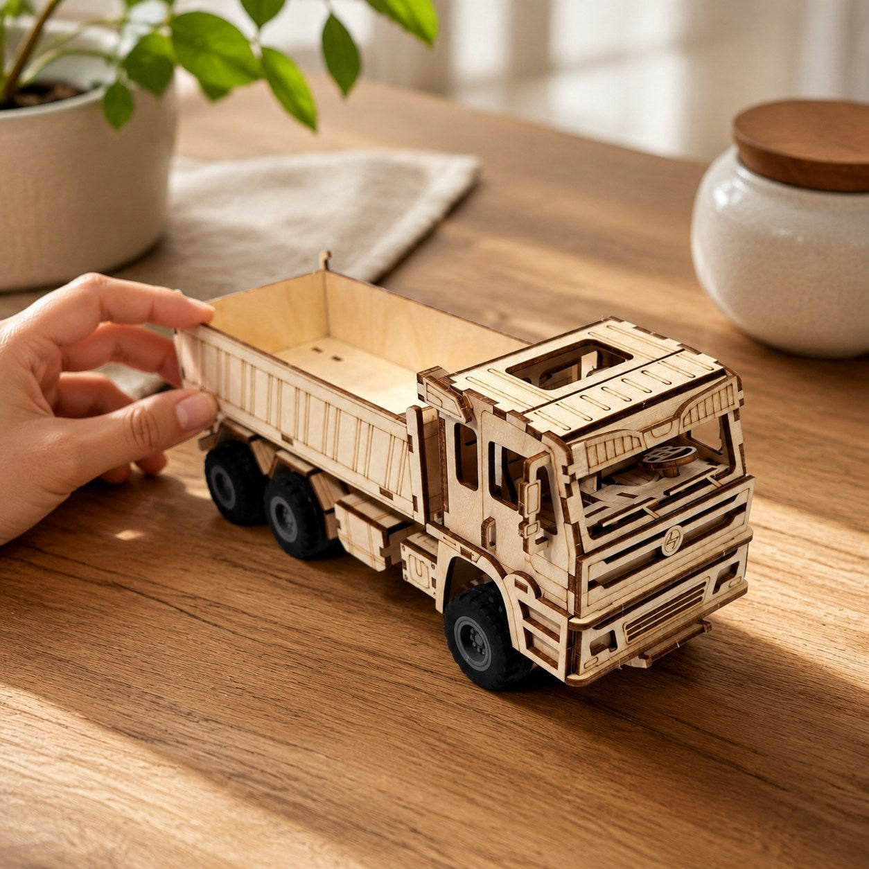 Hand next to finished wooden dump truck showing scale