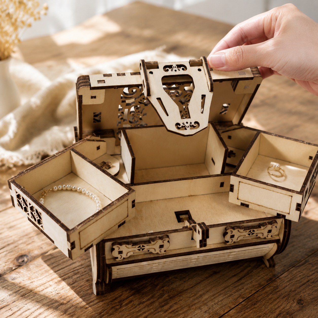 Hand opening the multi-tier wooden treasure box showing scale