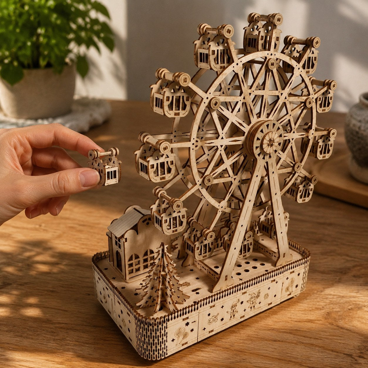 Hand next to the assembled Winter Ferris Wheel 3D Wooden Puzzle showing scale