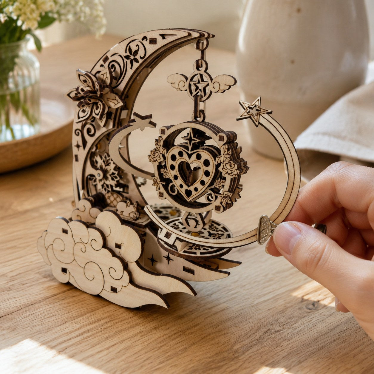 Hand winding the celestial 3D wooden puzzle music box