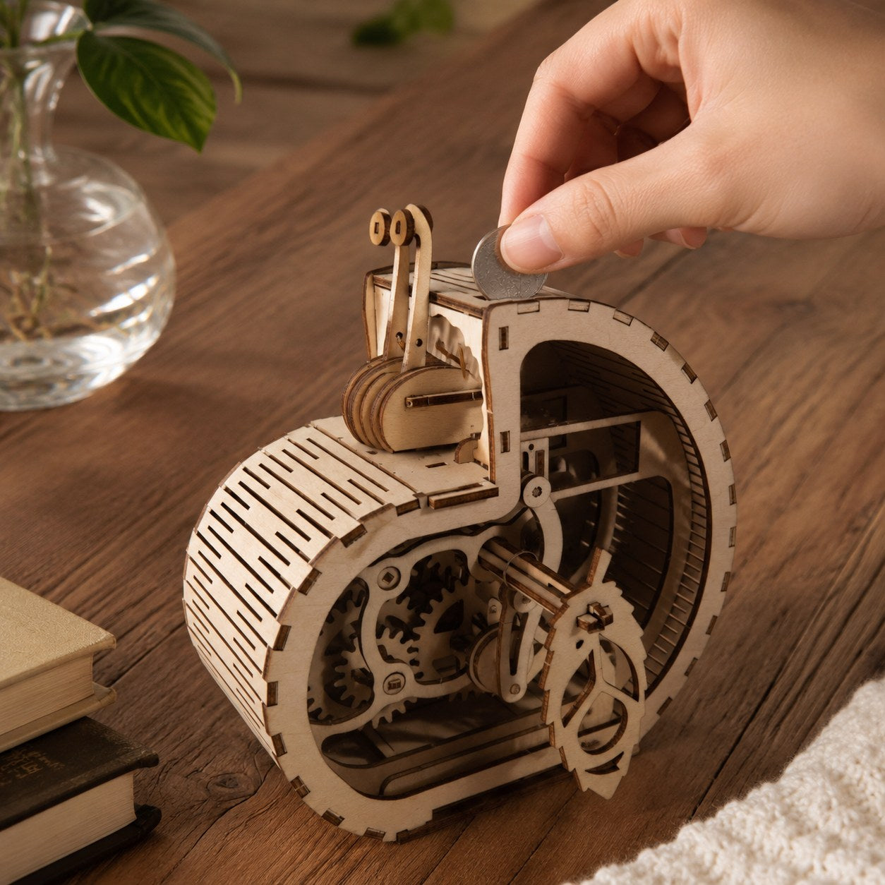 Adult hand next to the finished wooden snail coin bank