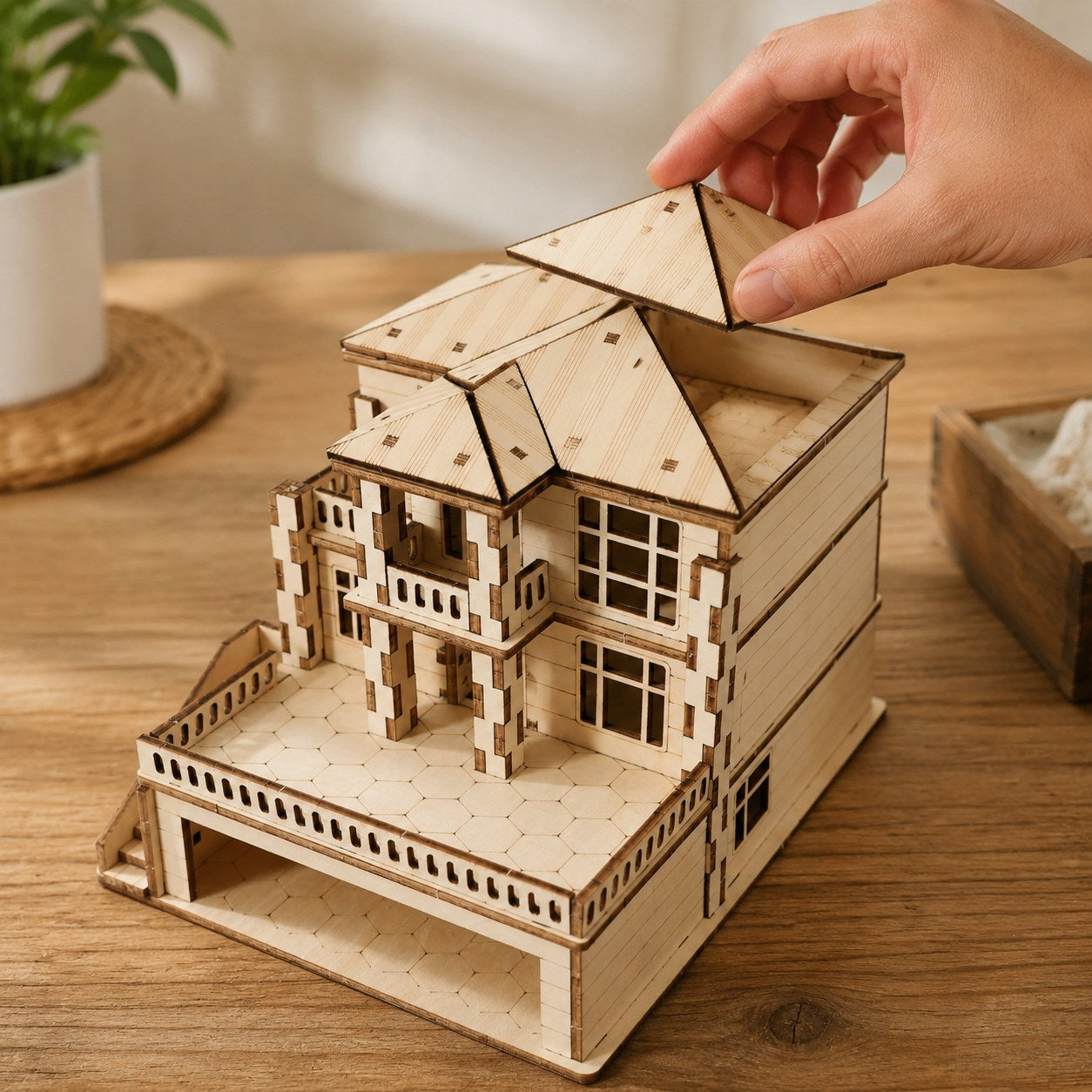 Hand adjusting the roof of the Modern Villa wooden model for scale