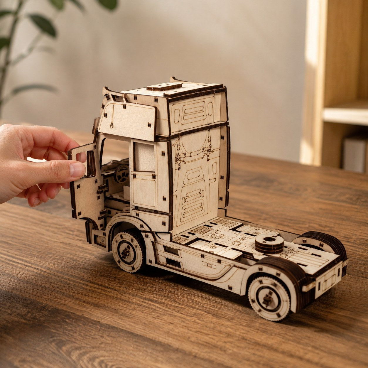 Adult hand opening the door of the finished wooden semi truck model to show scale