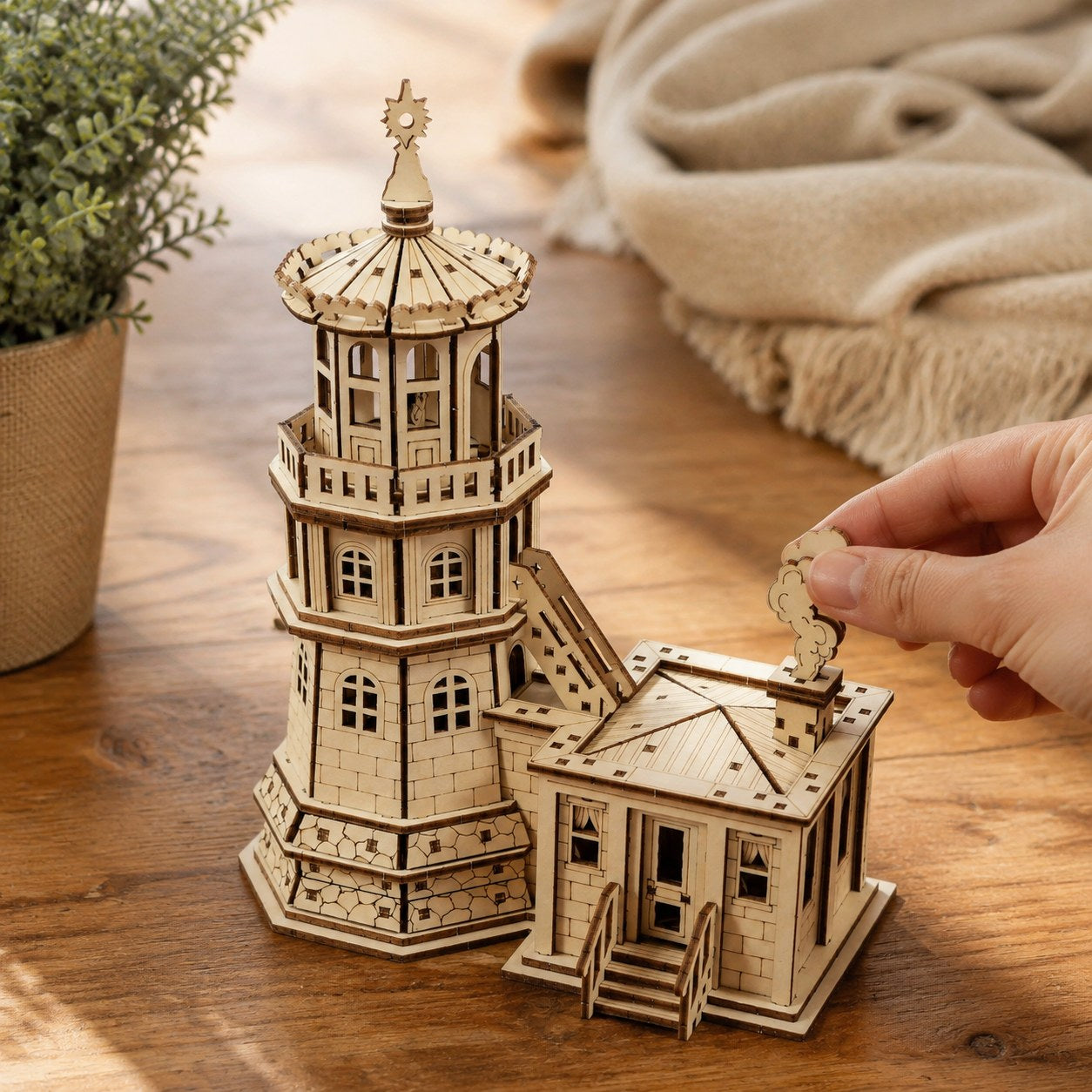 Hand placing a piece on the Coastal Lighthouse 3D Wooden Puzzle to show scale