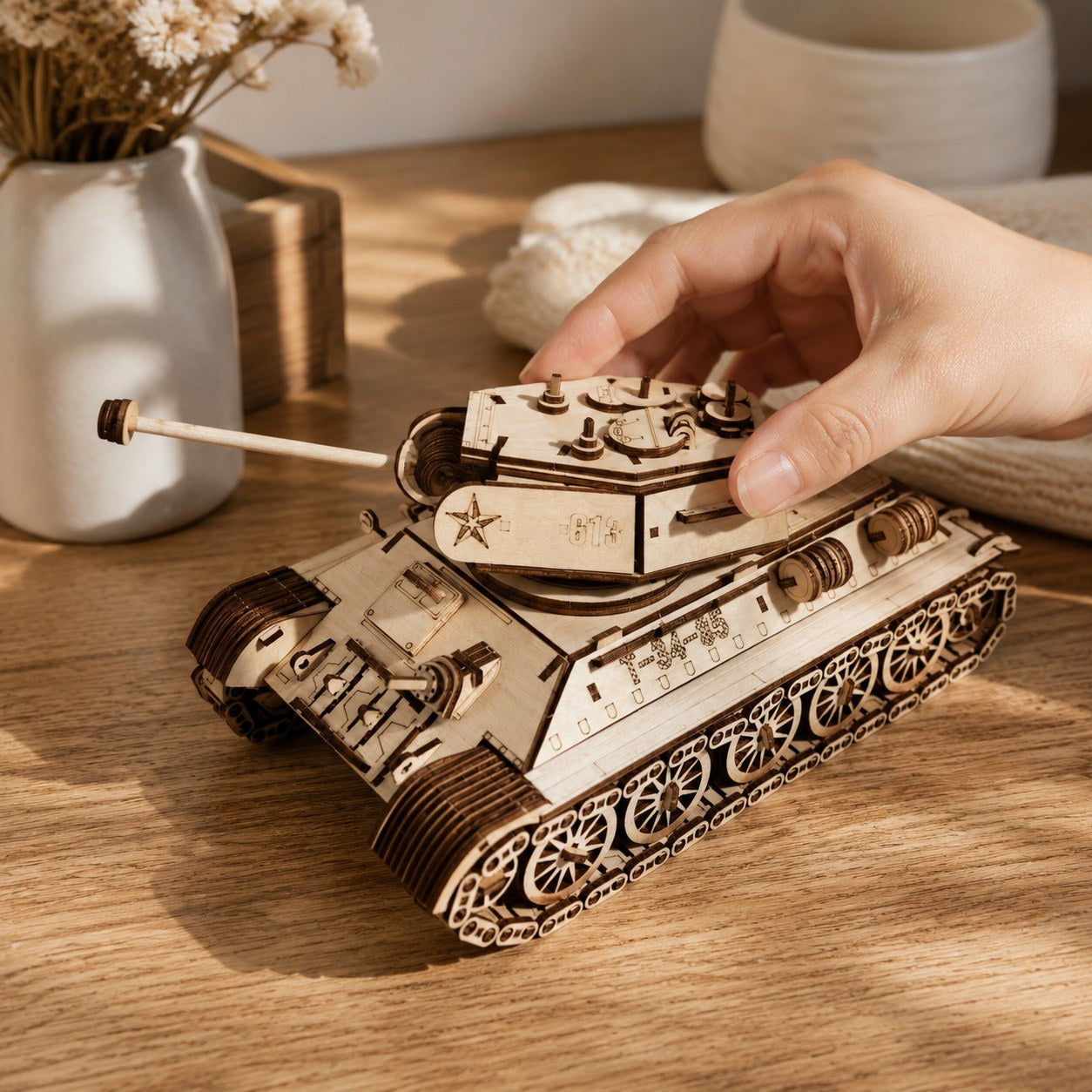 Hand adjusting the turret of the wooden tank model for scale