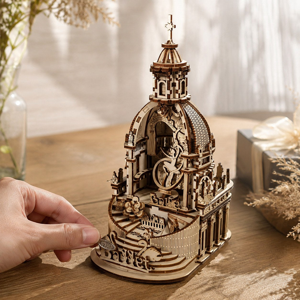 Hand winding up the mechanical Swan Lake wooden music box to show scale