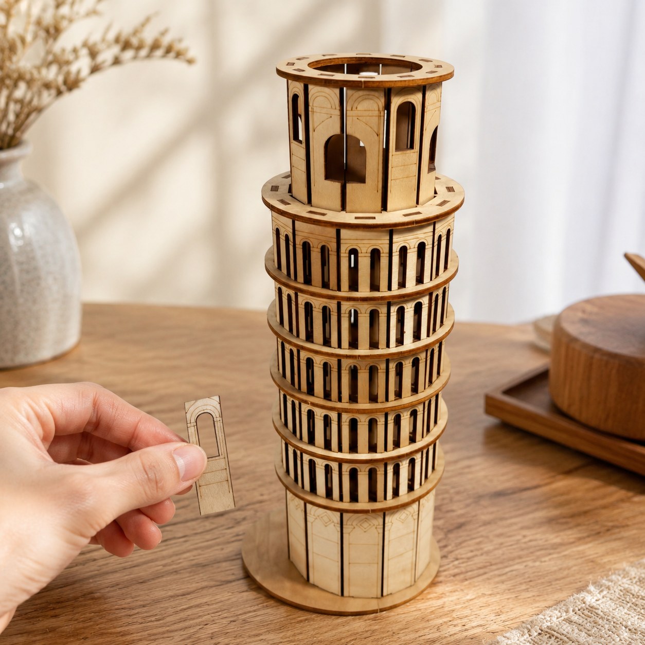 Hand next to the completed Leaning Tower of Pisa wooden model showing its 11.3-inch height