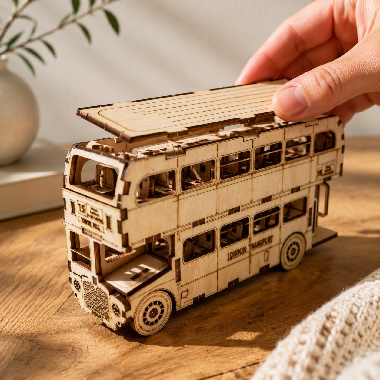 Hand placing a piece on the wooden London bus puzzle for scale