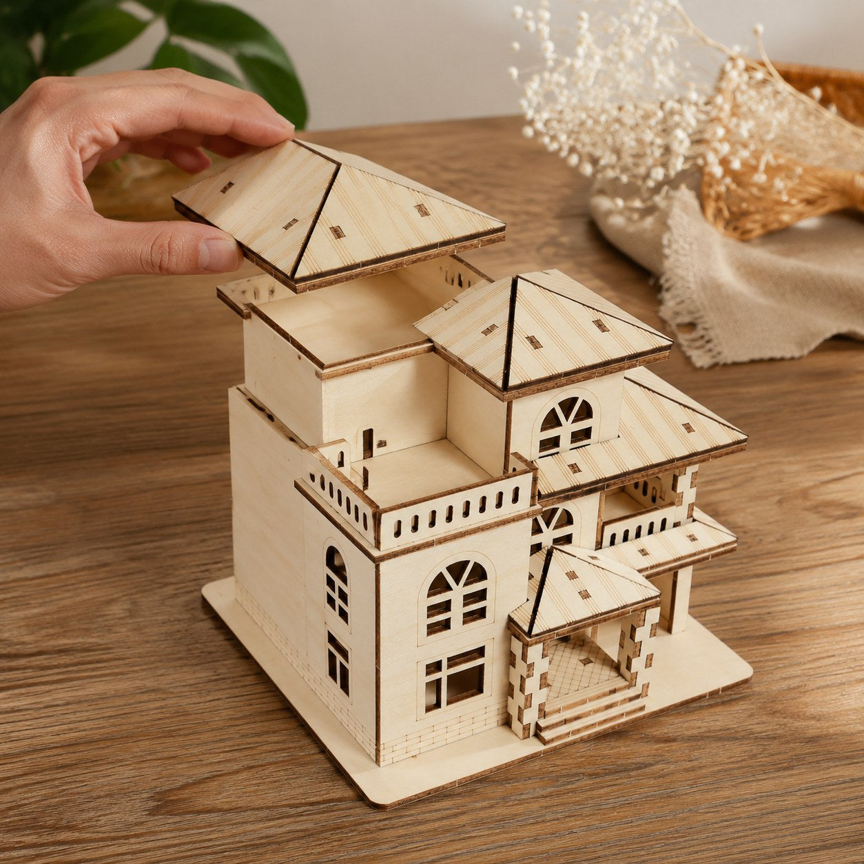 Adult hand adjusting the roof of the Modern Villa 3D Wooden Puzzle to show scale