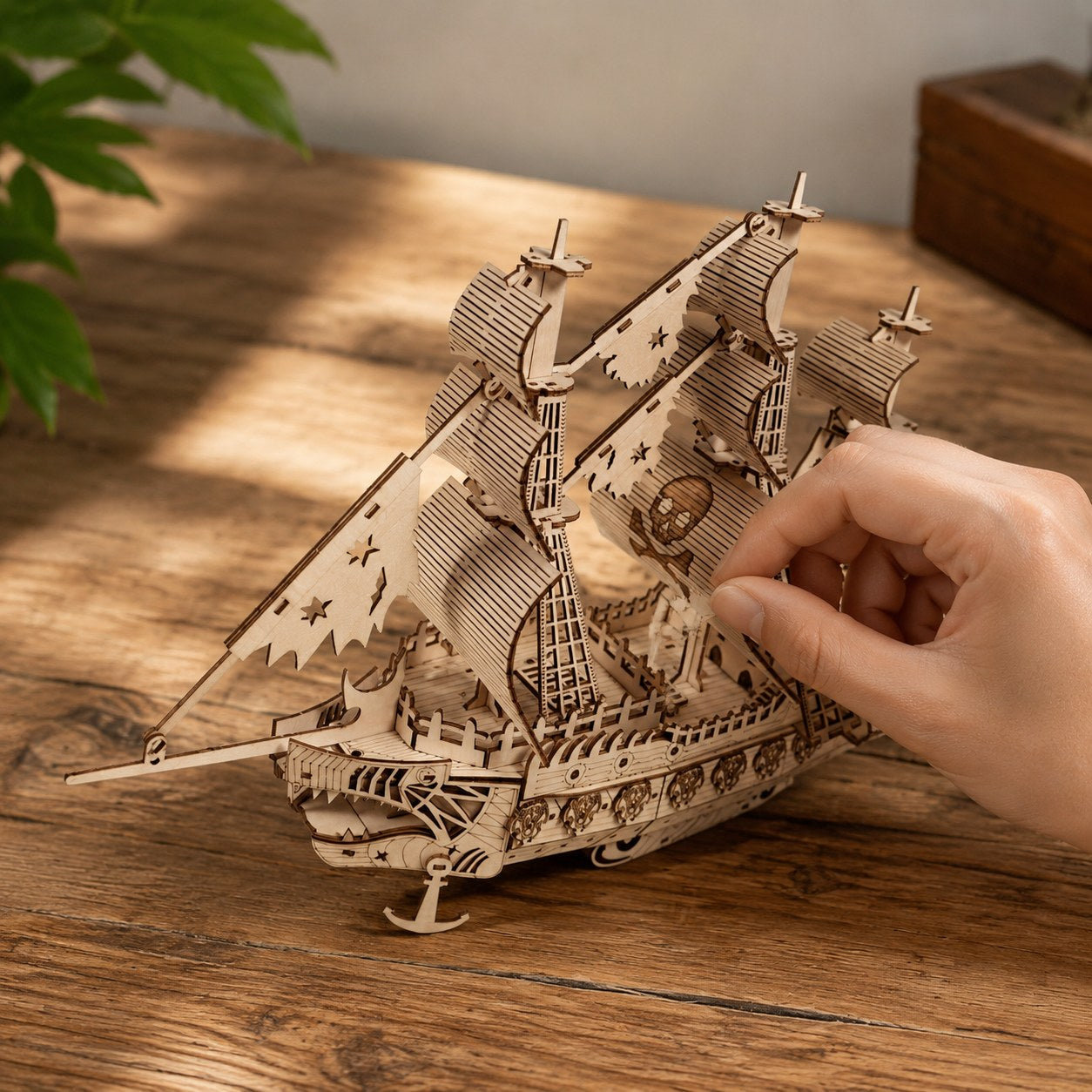 Hand adjusting the finished wooden pirate ship model to show scale