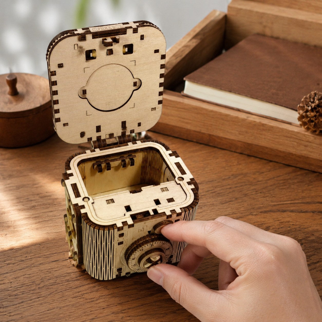Hand turning the combination dial on the wooden cipher box showing real scale