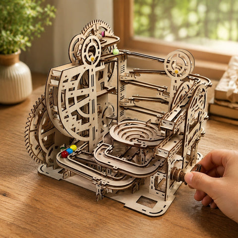 Hand turning the crank of the wooden marble run