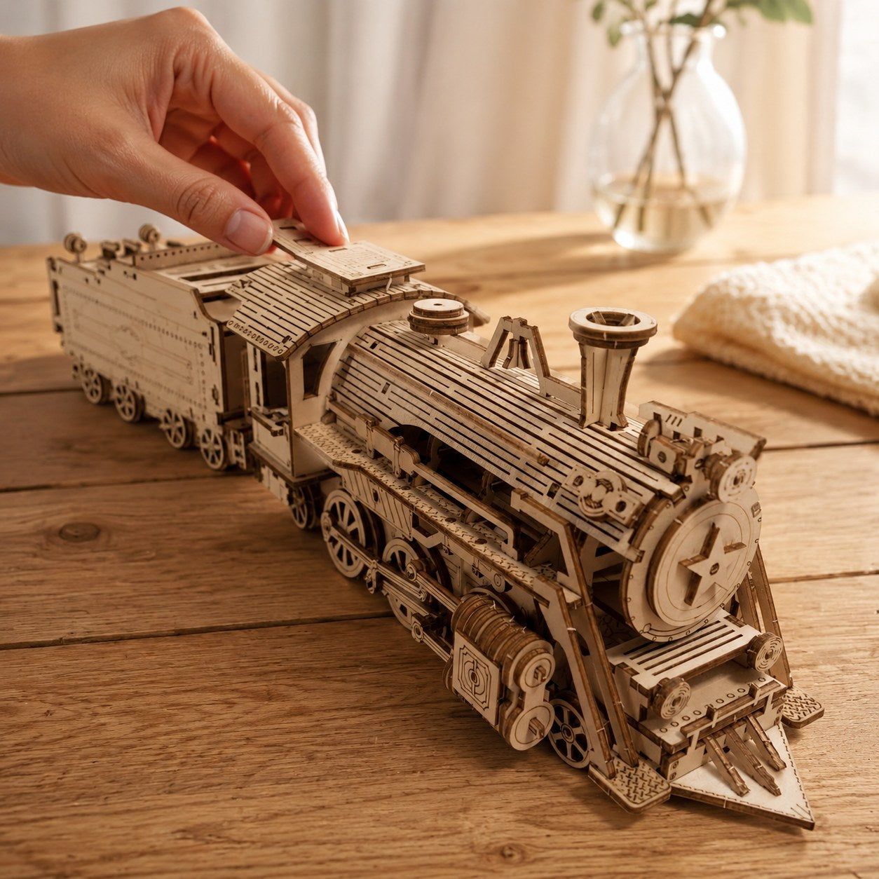 Hand placing a piece on the finished wooden train puzzle to show size.
