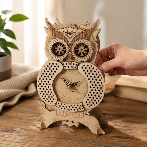 Hand touching the assembled owl clock to show scale