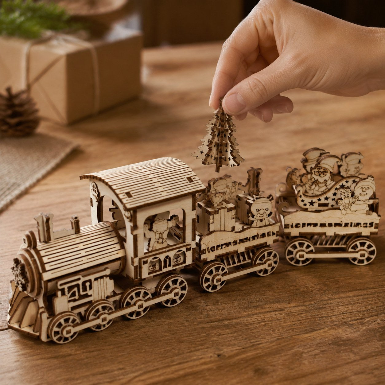 Hand placing a wooden piece into the Christmas train for scale