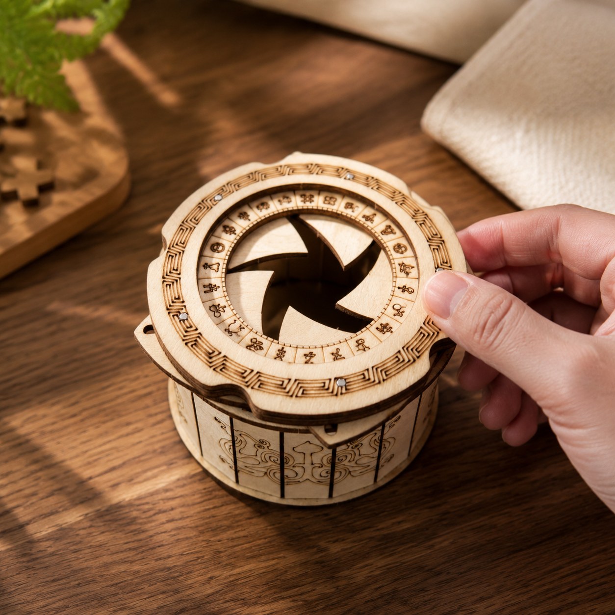 Hand operating the mechanical iris lid of the wooden puzzle box