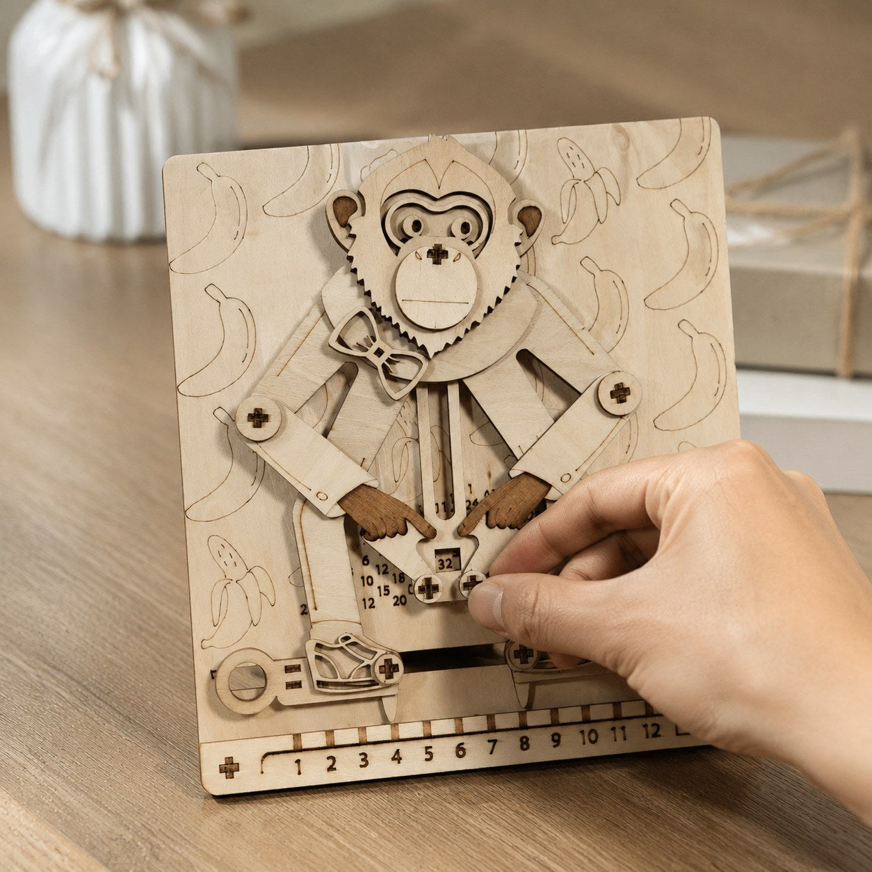 Adult hand next to the wooden math monkey showing scale