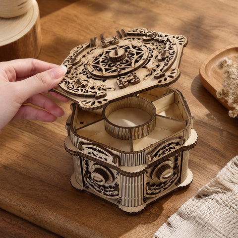 Hand opening the lid of the wooden jewelry box to show scale