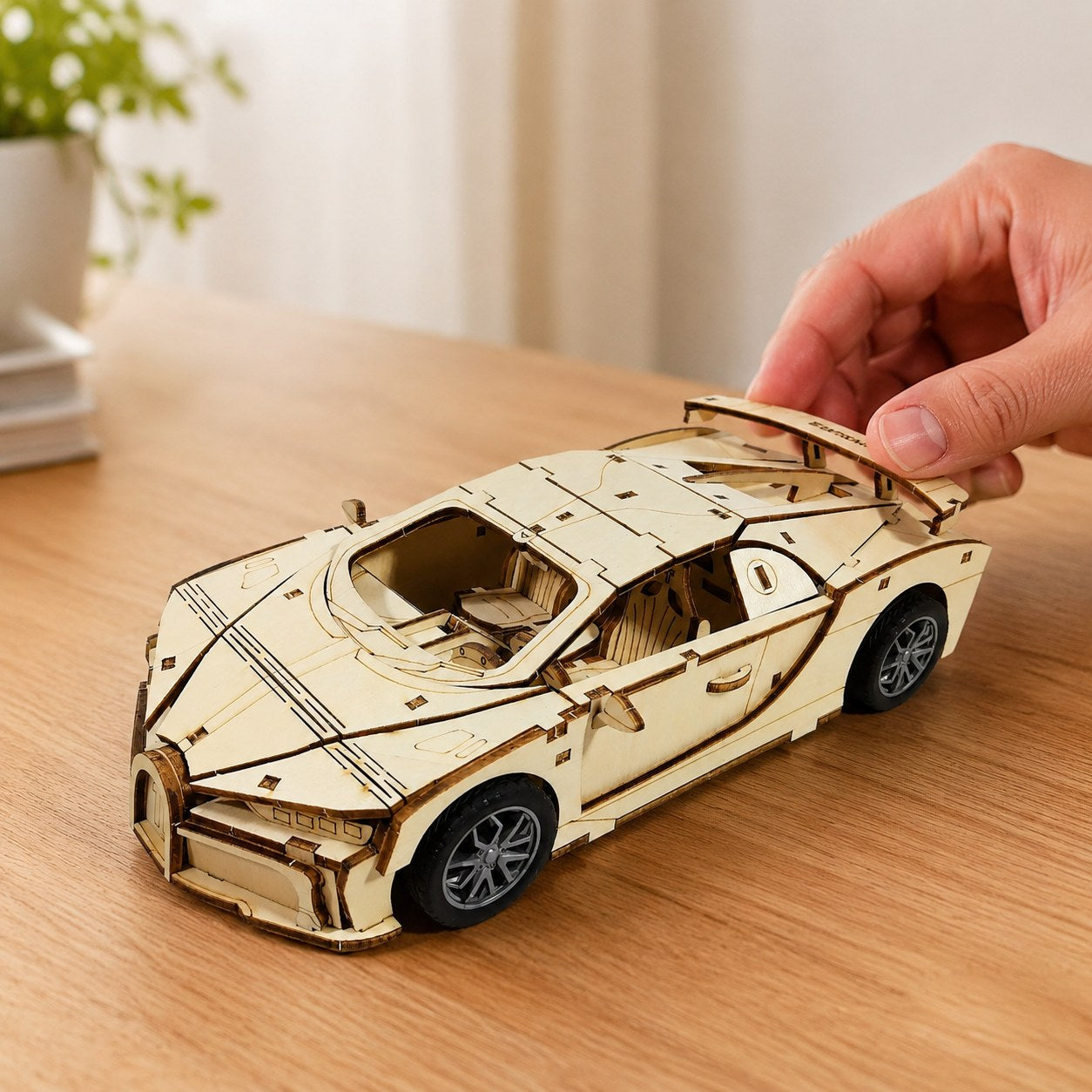 Hand adjusting the finished wooden supercar to show scale