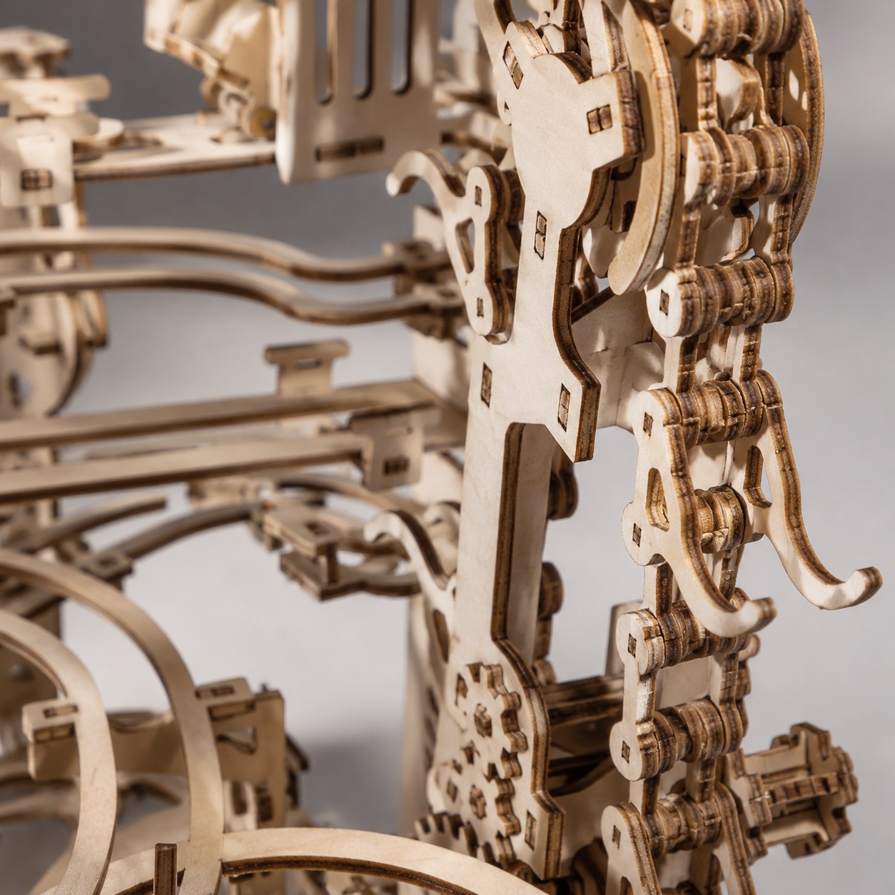 Macro close-up showing wooden gears and laser-cut details of the mechanical marble run.