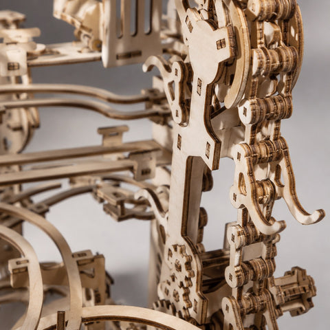 Macro close-up showing wooden gears and laser-cut details of the mechanical marble run.