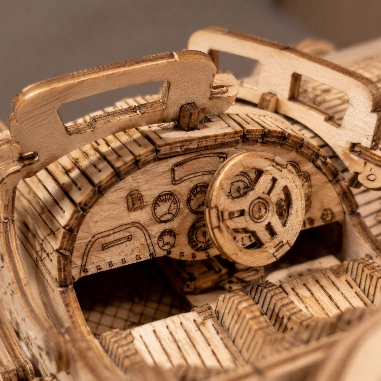 Extreme close-up of the laser-cut wooden dashboard and steering wheel of the vintage sports car puzzle.