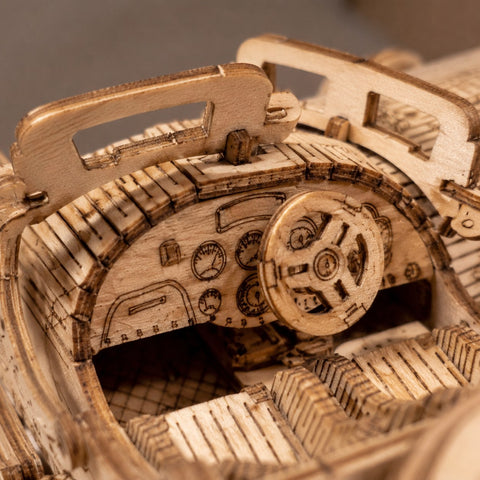 Extreme close-up of the laser-cut wooden dashboard and steering wheel of the vintage sports car puzzle.