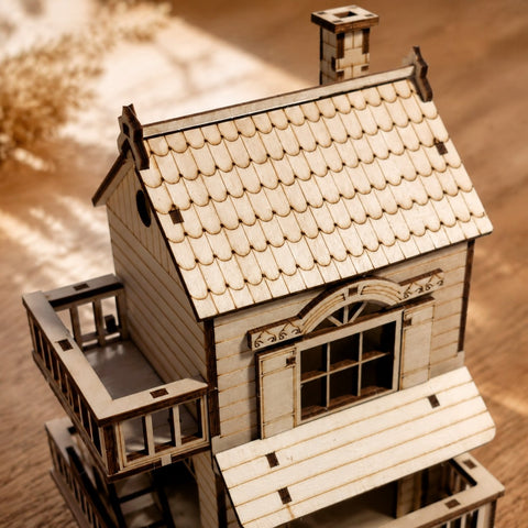 Macro close-up of the laser-cut scalloped roof and balcony details on the wooden puzzle