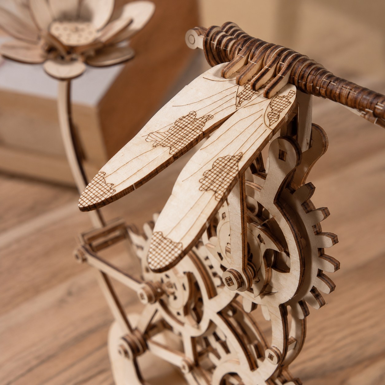 Close-up detail of the laser-cut wood gears and dragonfly wings