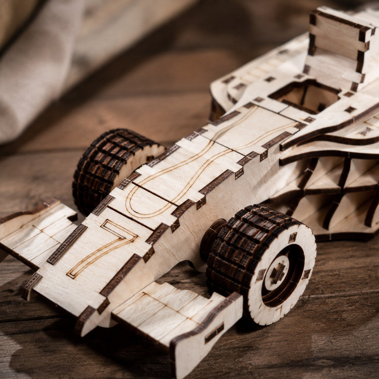 Close-up of laser-cut wood details on race car puzzle