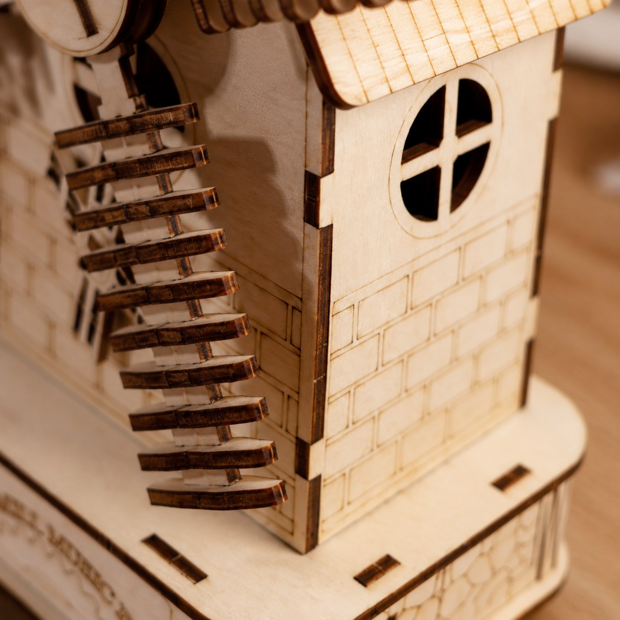 Macro close-up of laser-cut wood details and engraved brickwork on the windmill puzzle