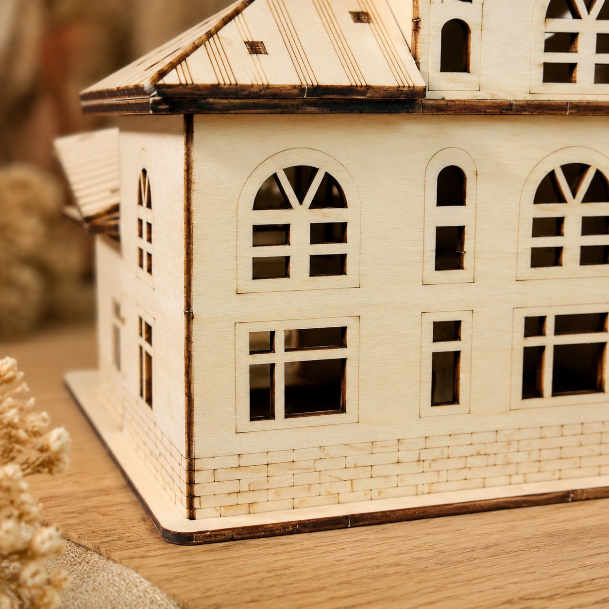 Macro close-up showing the laser-cut arched windows and brick details of the wooden villa