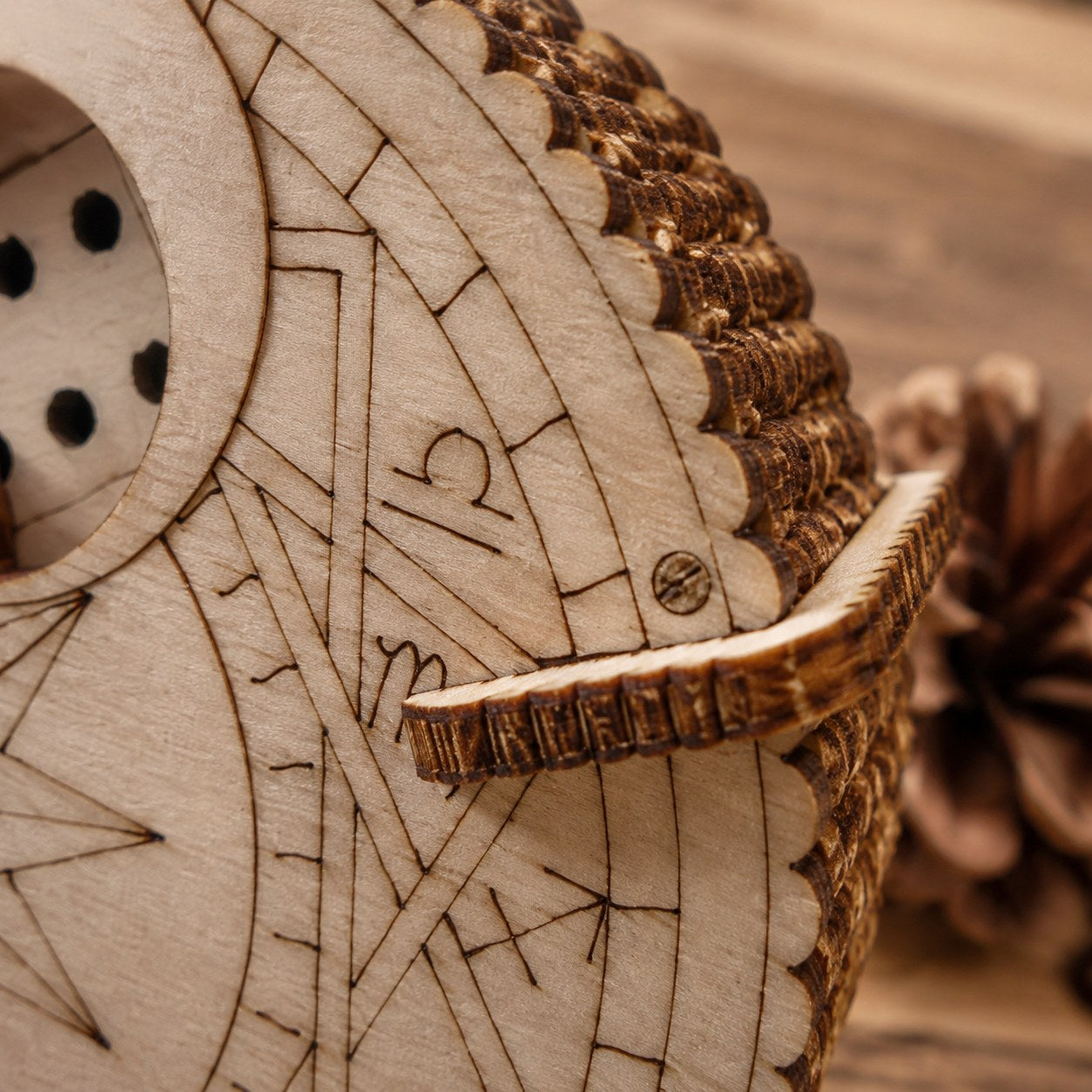 Macro close-up of laser-engraved zodiac details on the wooden puzzle