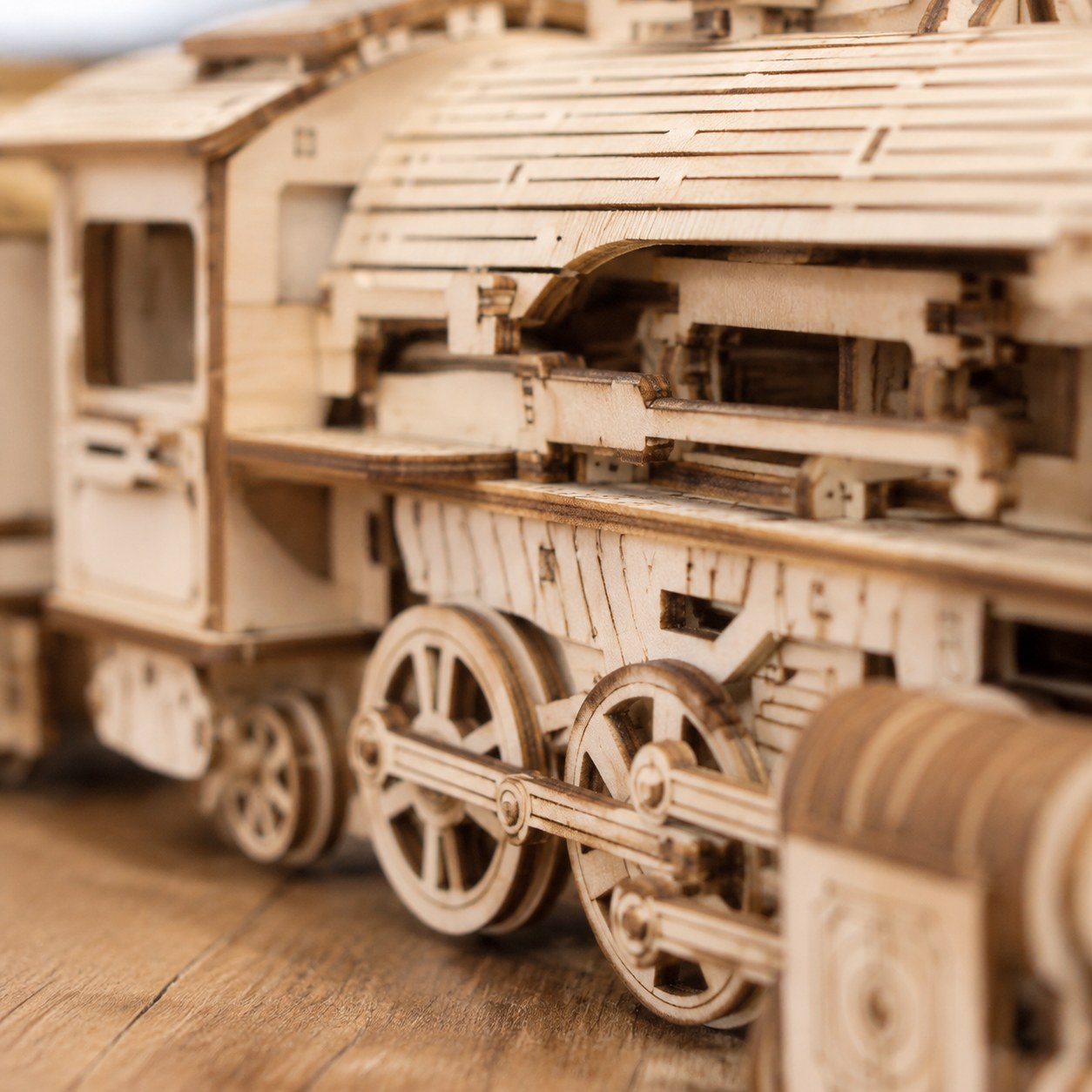 Close-up of the laser-cut wood details and wheels on the train model.
