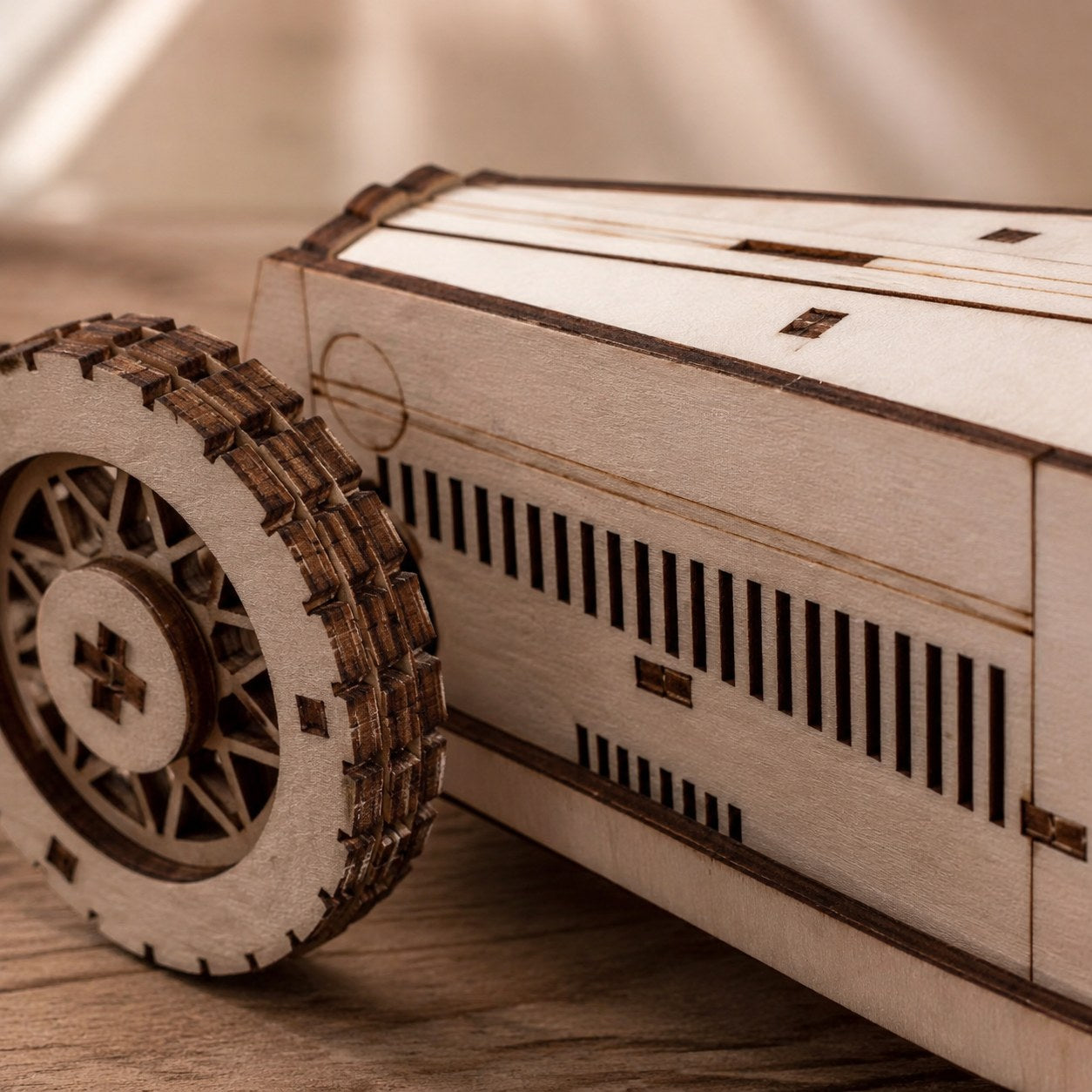 Macro close-up of the laser-cut wood details and spoked wheels on the race car puzzle