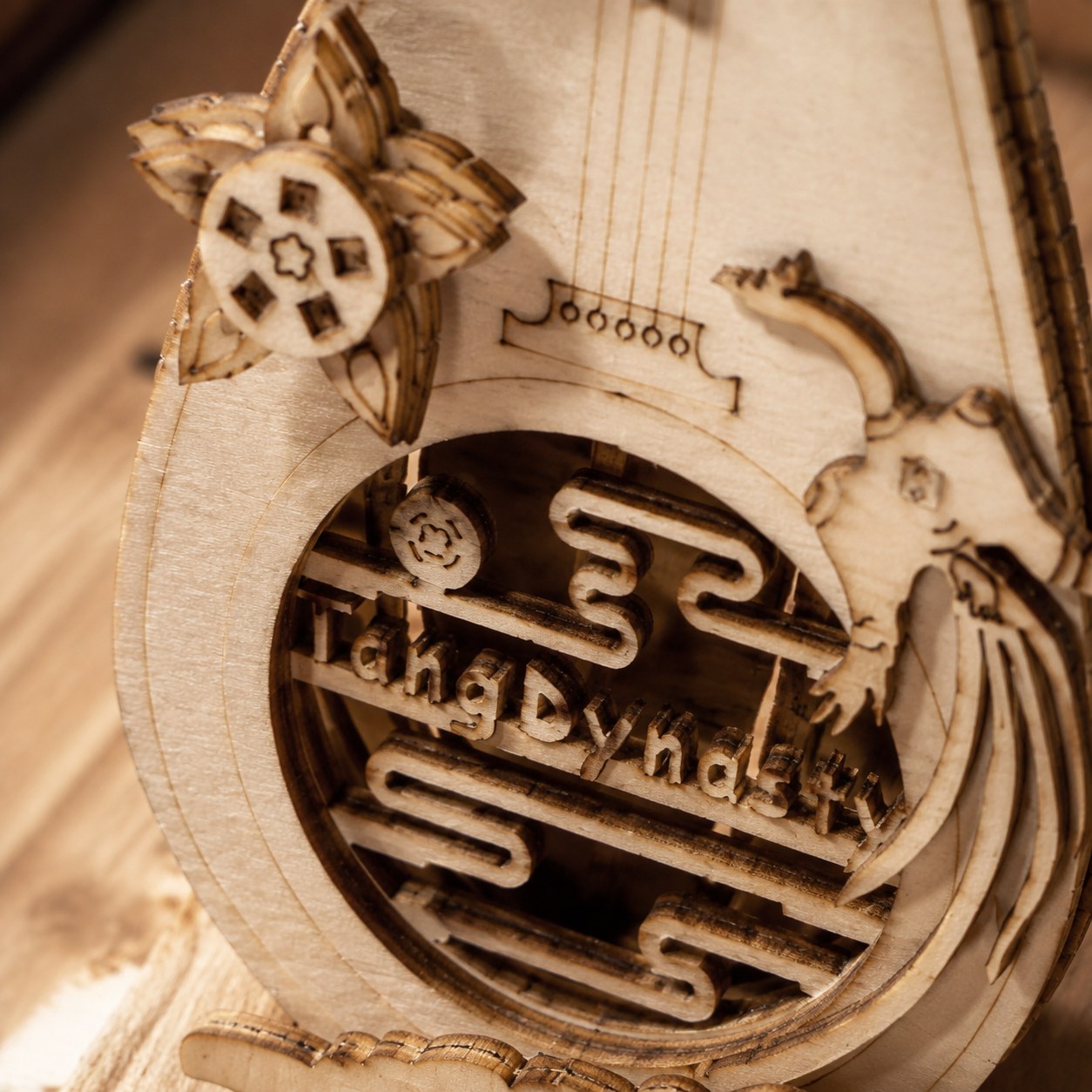 Macro close-up of the laser-cut wood details and Tang Dynasty text on the Pipa model