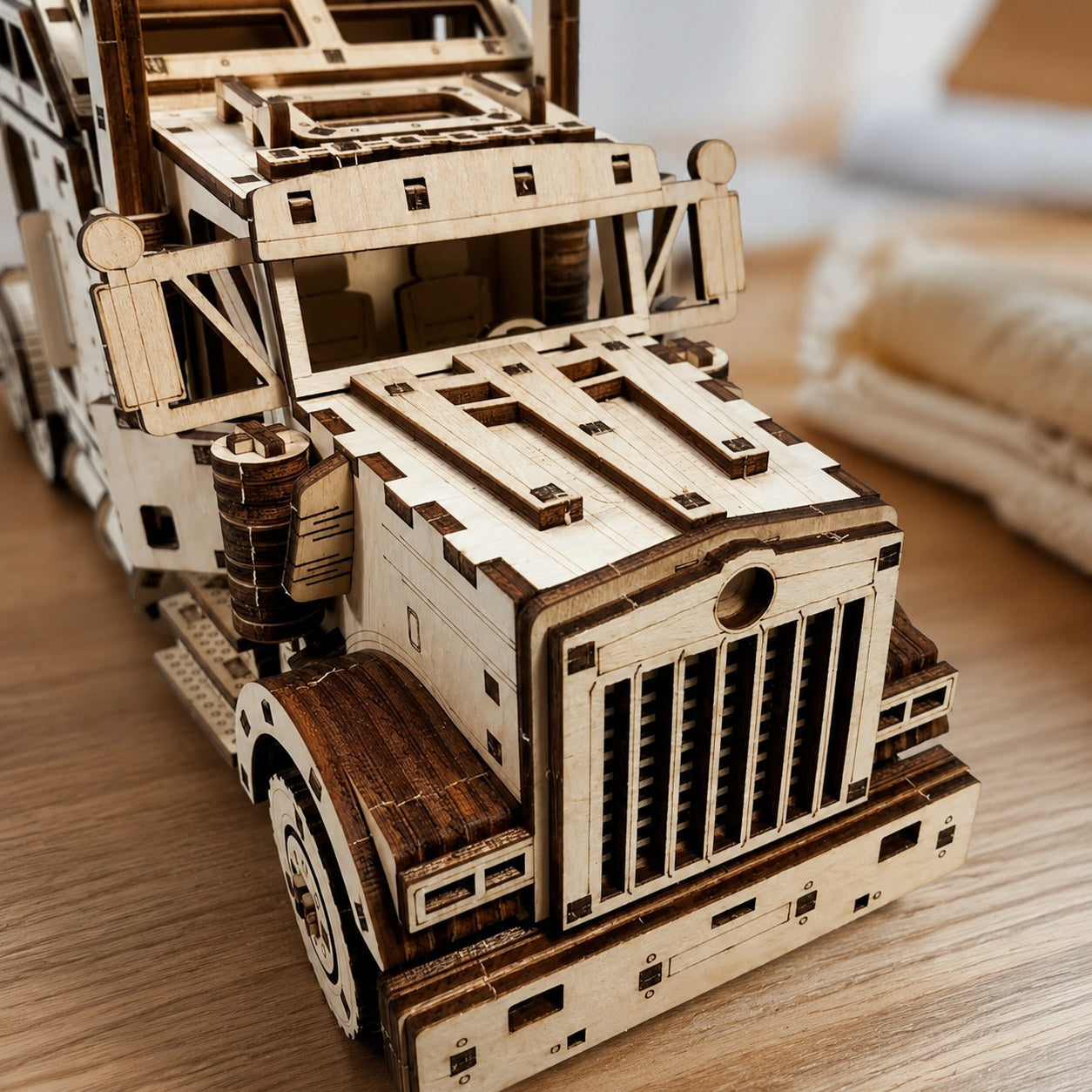 Macro close-up of the front grille and exhaust stacks on the wooden semi-truck model