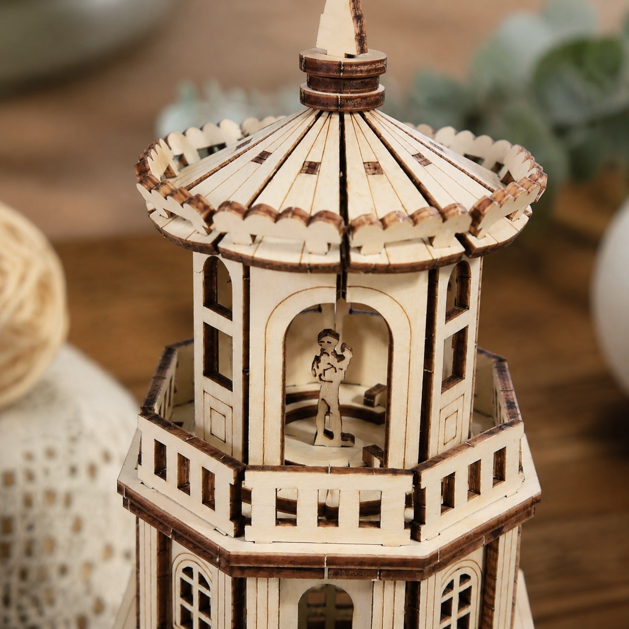 Close-up of the laser-cut wood details and keeper silhouette on the lighthouse model